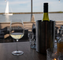Drinking white dry wine in outdoor cafe with sea view