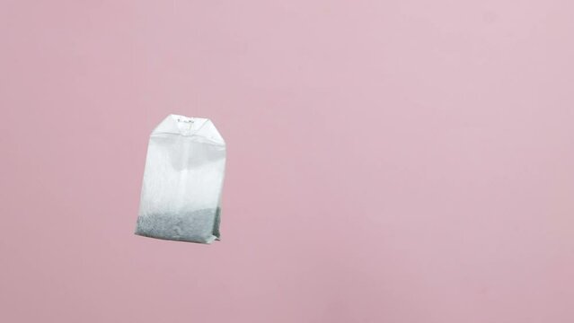 a tea bag spinning on a pink background