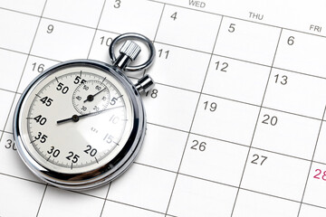 Stopwatch on calendar background. Blank calendar cells