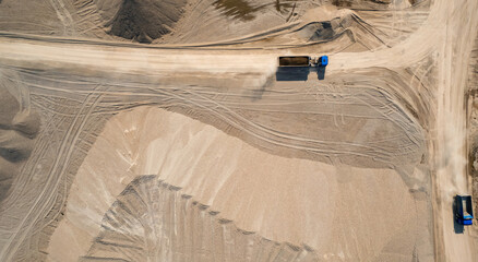 Limestone mining in open quarry, industrial truck with dump stone, aerial top view