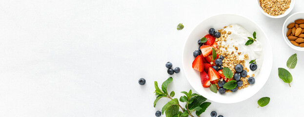 Breakfast bowl with granola, plain yogurt, strawberry and blueberry. Top view. Banner - obrazy, fototapety, plakaty