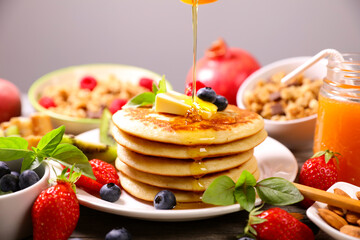 pile of pancakes with maple syrup pouring