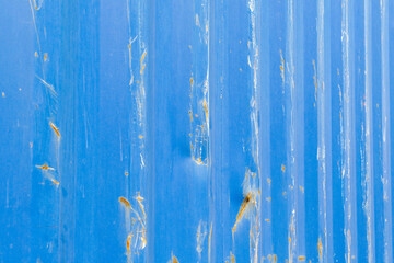blue sheet metal wall with grooves and rust and abrasion