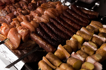 Meat and potatoes with lard on skewer, cooked on the grill, fragrant atmosphere of street food.