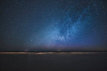 Night skyscape of a starry sky at the seashore. Stars constellations and Milky Way galaxies in the...
