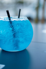 blue cocktail in the shape of a fishbowl to share. new cocktail in crystal glass