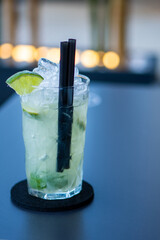 Brazilian caipirinha cocktail in a crystal glass, with cachaça, lime, ice and sugar
