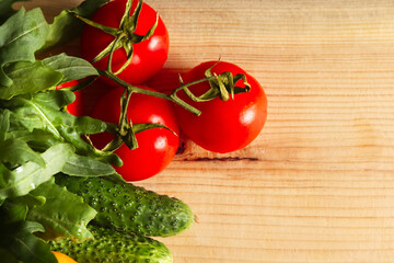 Overhead view of a delicious assortment of farm fresh vegetables and herbs spread out on a rustic wooden table.