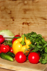 Overhead view of a delicious assortment of farm fresh vegetables and herbs spread out on a rustic wooden table.