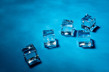 Clear ice cubes for cooling drinks on a blue background.