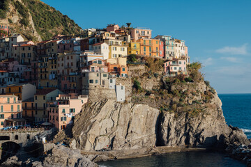Fototapeta na wymiar Beautiful view of rocky hills and colorful historic buildings of Manarola, tourist attraction and famous place in Liguria, Italy.