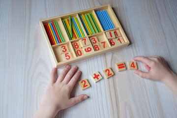 Wooden figures on the desk. Primary school, first grade. mathematics. Two plus two equals four