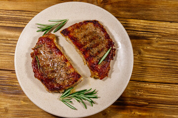 Grilled pork steaks with rosemary on wooden table. Top view
