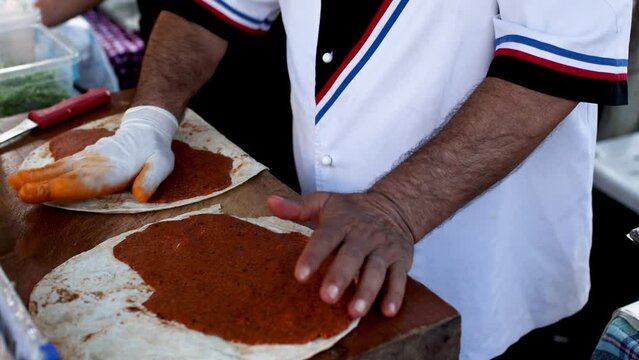 Cooking traditional turkish dish at street food festival, chef preparing lavash, bulgur and lettuce dish, turkish cuisine vegetarian dish, cig kofte