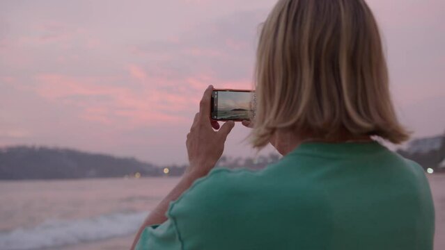 Cinemagraph of female hands hold smartphone new generation oled screen, makes photo or video for social media network, waves keep moving in loop. Inspiration to travel world