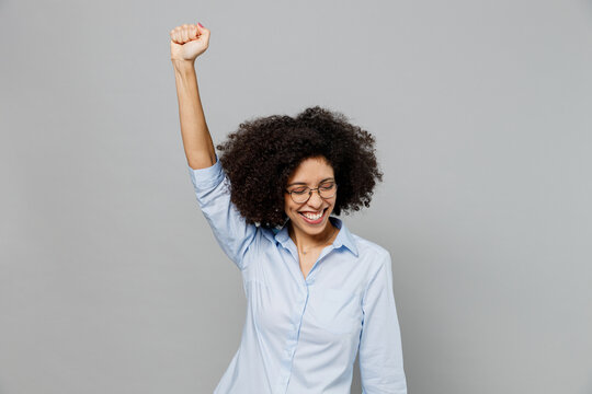 Young Excited Fun Employee Business Corporate Lawyer Woman Of African American Ethnicity In Classic Formal Shirt Work In Office Doing Winner Gesture Celebrate Isolated On Grey Color Background Studio.