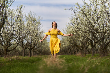 Happy woman in the blooming orchard