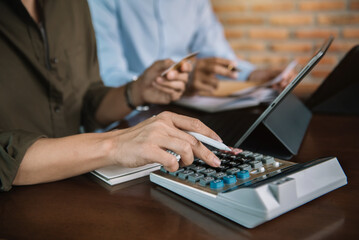 Obraz na płótnie Canvas Businessman and partner using calculator and laptop for calculation finance, tax, accounting, statistics and analytic research concept. in the office.