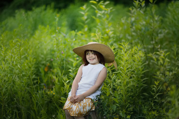 Obraz premium Cute kid girl playing in grass in park, child among vegetation in forest