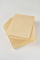 Close up of stack of wafer or waffle sheets on a white background. Shallow depth of field
