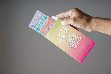 hand holding hari raya envelope 