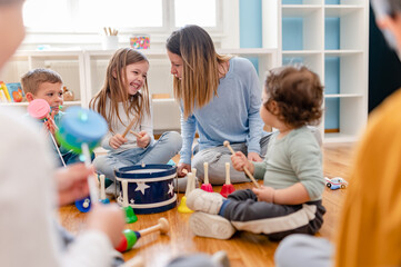 Parents taking part in the music class of a kindergarten. Teacher and parents working together....