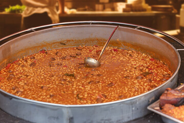 Beans stew, chili sin carne, large pot on fire cooking during food festival