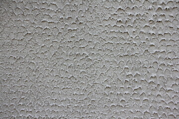 Grey plastered wall with a scaly texture. Concrete wall background. 
