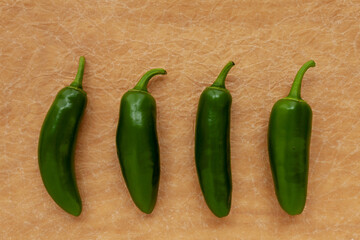 Green raw Jalapeno peppers top view on paper table.