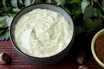 Bechamel sauce with spices: nutmeg and mustard powder blend in a bowl. Homemade white sauce.