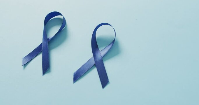 Video of two dark blue colon cancer ribbons on pale blue background