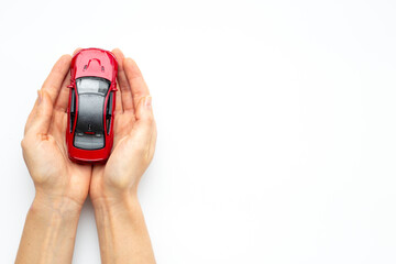 Car insurance or driving safety concept. Toy car in hands