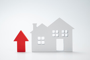 a red up arrow and house. The concept of the rising price of real estate