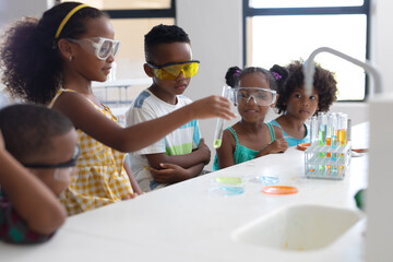 African american elementary school students performing scientific experiment during chemistry class - Powered by Adobe