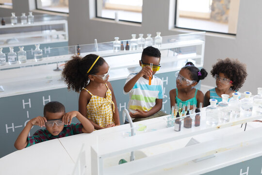 African american elementary school students performing chemical experiment in laboratory