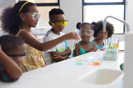 African american elementary school students performing scientific experiment during chemistry class