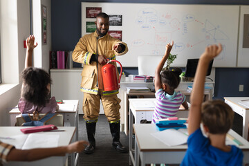 African american young male teacher pointing on multiracial elementary students in safely education