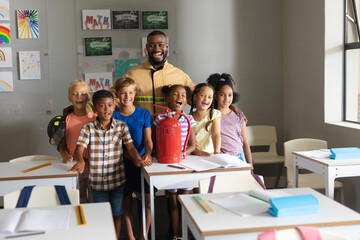 Multiracial elementary students and african american young male teacher with fire extinguisher