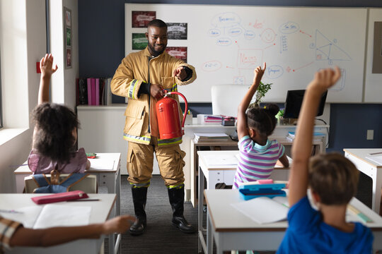 African american young male teacher pointing on multiracial elementary students in safely education