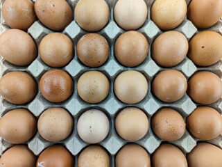 Close up of fresh eggs in cardboard box at stall of supermarket in Asia. Healthy nutrition and protein. Flat lay.