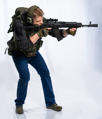 photograph of a fully equipped soldier standing in tactical attire against a white background.