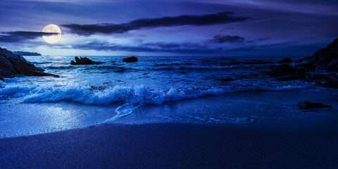 empty beach at night. beautiful landscape at the sea. waves washing the sand and stones on the...