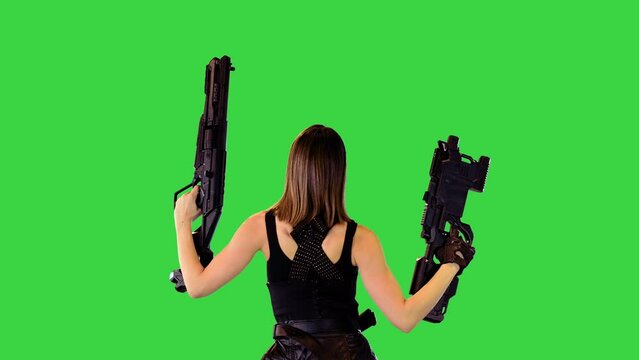 Cyberpunk girl walks with machine guns raised, making a series of shots on a Green Screen, Chroma Key.