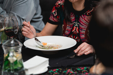 Woman eating mushroom cream soup in a restaurant