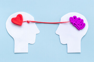 Communication and relationship concept - brain and heart on two paper human heads