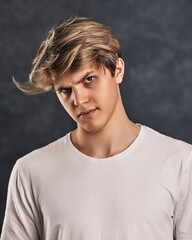 young man frowning on gray background. Human emotions