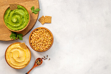 Obraz na płótnie Canvas Hummus with snacks set - various types of hummus in bowls