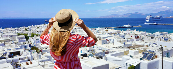 Panoramic view of a tourist girl looking at cruise ship that docks in the port of Mykonos, Cyclades...