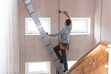 Fototapeta Electrician checking lighting to the ceiling in the home, technician concept obraz