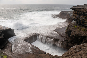 Ocean flows into Dún Aonghasa and cliffs of Inishmore, Aran islands, county Galway, Ireland....
